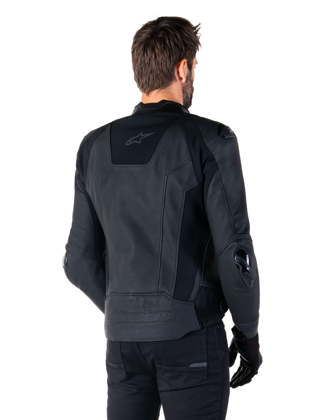 Alpinestars Missile V3 Leather Jacket, chaqueta de cuero negra, vista trasera en modelo, chaqueta deportiva de competición premium con confección en cuero, con la marca Alpinestars en relieve en la parte inferior de la espalda y deslizadores de codo de TPU.