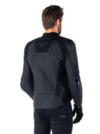 Alpinestars Missile V3 Leather Jacket, chaqueta de cuero negra, vista trasera en modelo, chaqueta deportiva de competición premium con confección en cuero, con la marca Alpinestars en relieve en la parte inferior de la espalda y deslizadores de codo de TPU.