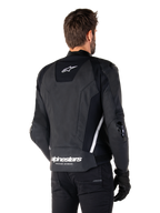 Chaqueta de cuero Alpinestars Missile V3, vista trasera, negro y blanco, con el logotipo de la estrella de Alpinestars en la parte superior de la espalda y el nombre de la marca en la parte inferior, deslizadores protectores en codos y hombros, equipamiento de carreras de cuero premium