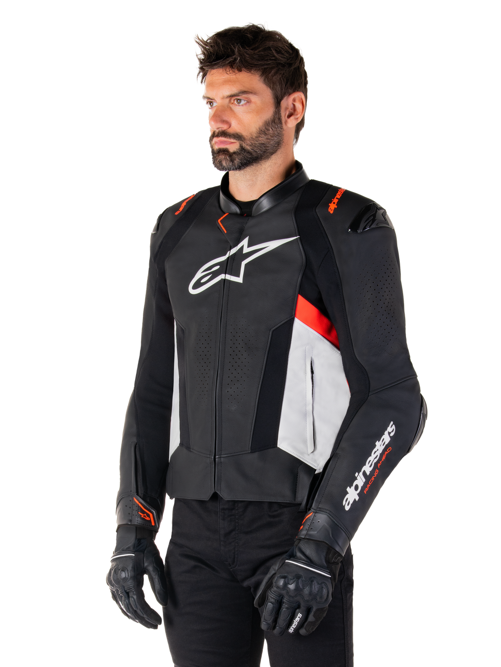 Chaqueta de cuero Alpinestars Missile V3, negro, blanco y rojo flúor, chaqueta de moto deportiva de competición usada por un modelo con guantes y pantalones negros, con paneles de cuero perforado y logotipos de Alpinestars destacados