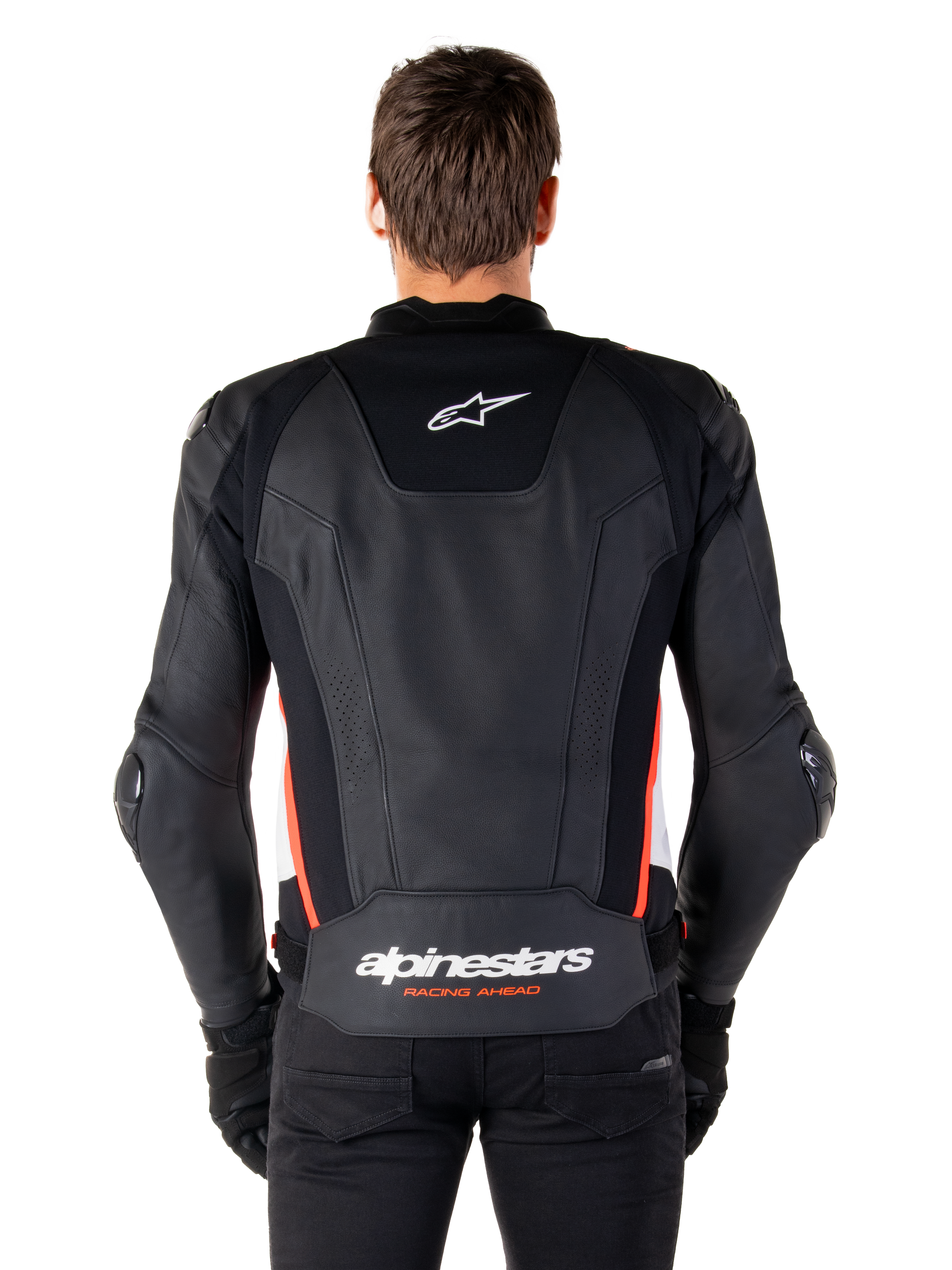 Chaqueta de cuero Alpinestars Missile V3, vista trasera, cuero negro premium con detalles en rojo flúor y blanco, con el logotipo de la estrella blanca en la parte superior de la espalda y la marca Alpinestars en la parte inferior de la espalda, usada con pantalones y guantes negros.