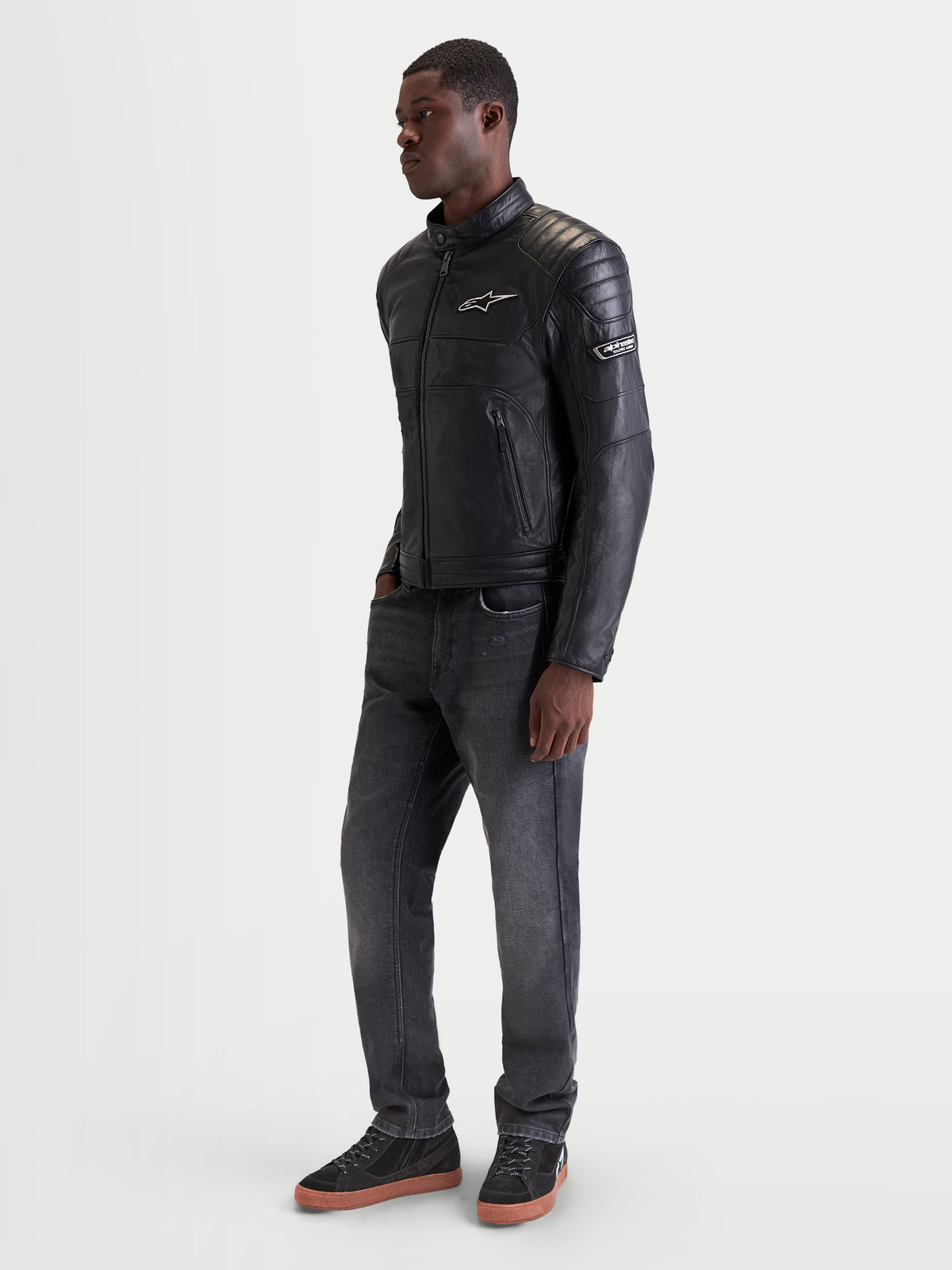 Alpinestars Revern Chaqueta de cuero, chaqueta de moto urbana de cuero para hombre en color negro, vista de perfil lateral en modelo que muestra estilo heritage y construcción en cuero bovino flor