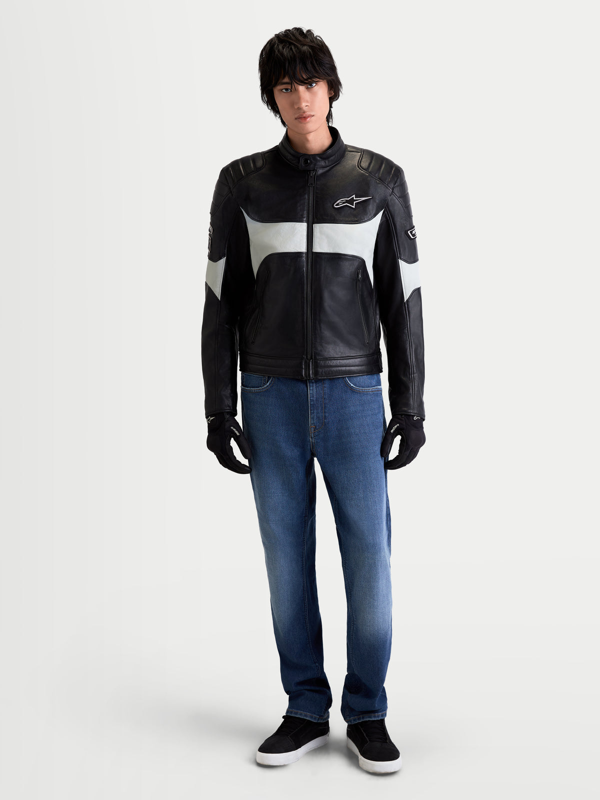 Alpinestars Revern Leather Jacket, men's urban motorcycle leather jacket in black and metal gray, front view on a model wearing jeans and black gloves, showcasing heritage styling and full-grain bovine leather construction