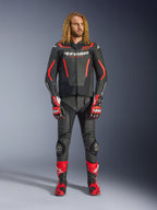 Male model wearing the Alpinestars GP Force V2 Leather Jacket in Black and Red Fluo, paired with matching leather pants, red racing gloves, and red performance boots, professional motorcycle sport gear