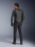 Vista trasera de un modelo vistiendo la Chaqueta de Cuero Alpinestars GP Force V2 en color Black Black, con una construcción de cuero de múltiples paneles y ajuste deportivo, combinada con pantalones de conducción, guantes y botas negros para un look completo inspirado en las carreras de motos.