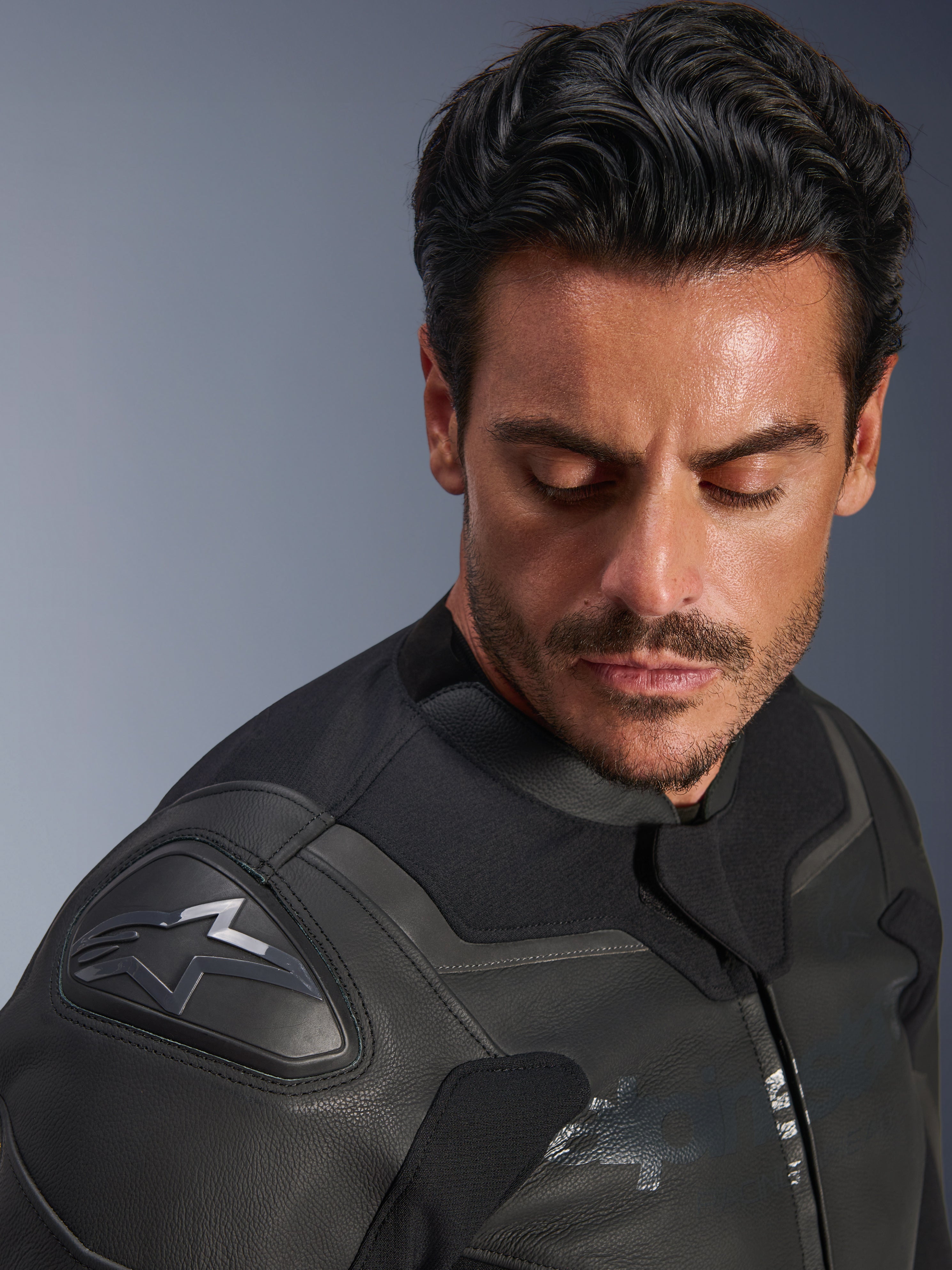 Chaqueta de cuero Alpinestars GP Force V2, color negro, primer plano de un modelo masculino usando la chaqueta, con enfoque en el hombro que incluye el protector GP Lite Evo DFS y el logotipo de Alpinestars, construcción de cuero multipanel premium