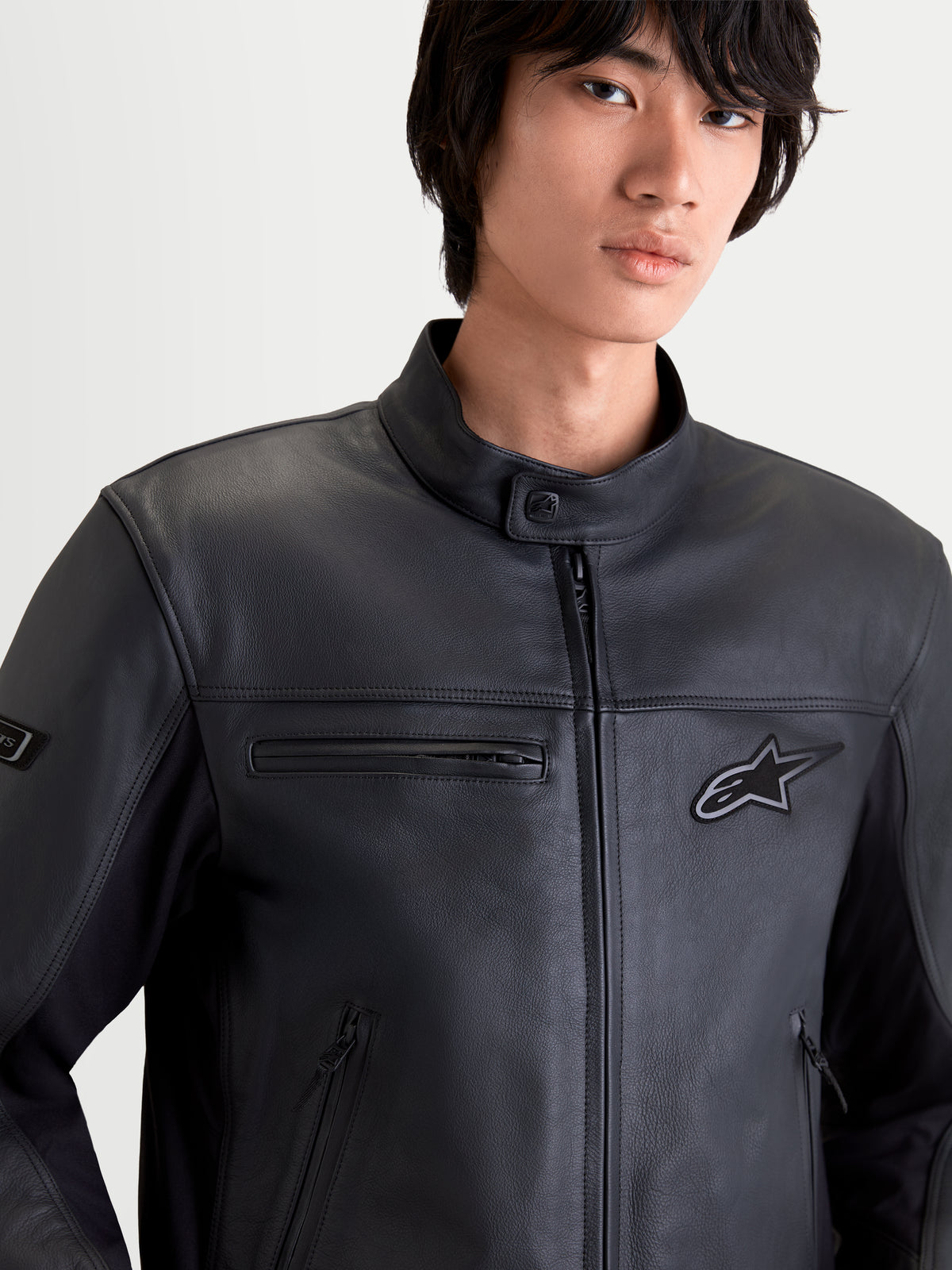Alpinestars Maver X Chaqueta de cuero, chaqueta de moto urbana contemporánea para hombre en color negro, vista frontal en primer plano de un modelo con equipamiento de cuero bovino premium, bolsillos con cremallera y cuello tipo motero