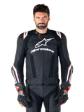 Chaqueta de cuero Alpinestars Missile V3 Ignition, negra con detalles en blanco y rojo, lucida por un modelo masculino con guantes y pantalones de carreras a juego, chaqueta deportiva de motociclismo derivada de MotoGP con logotipos llamativos