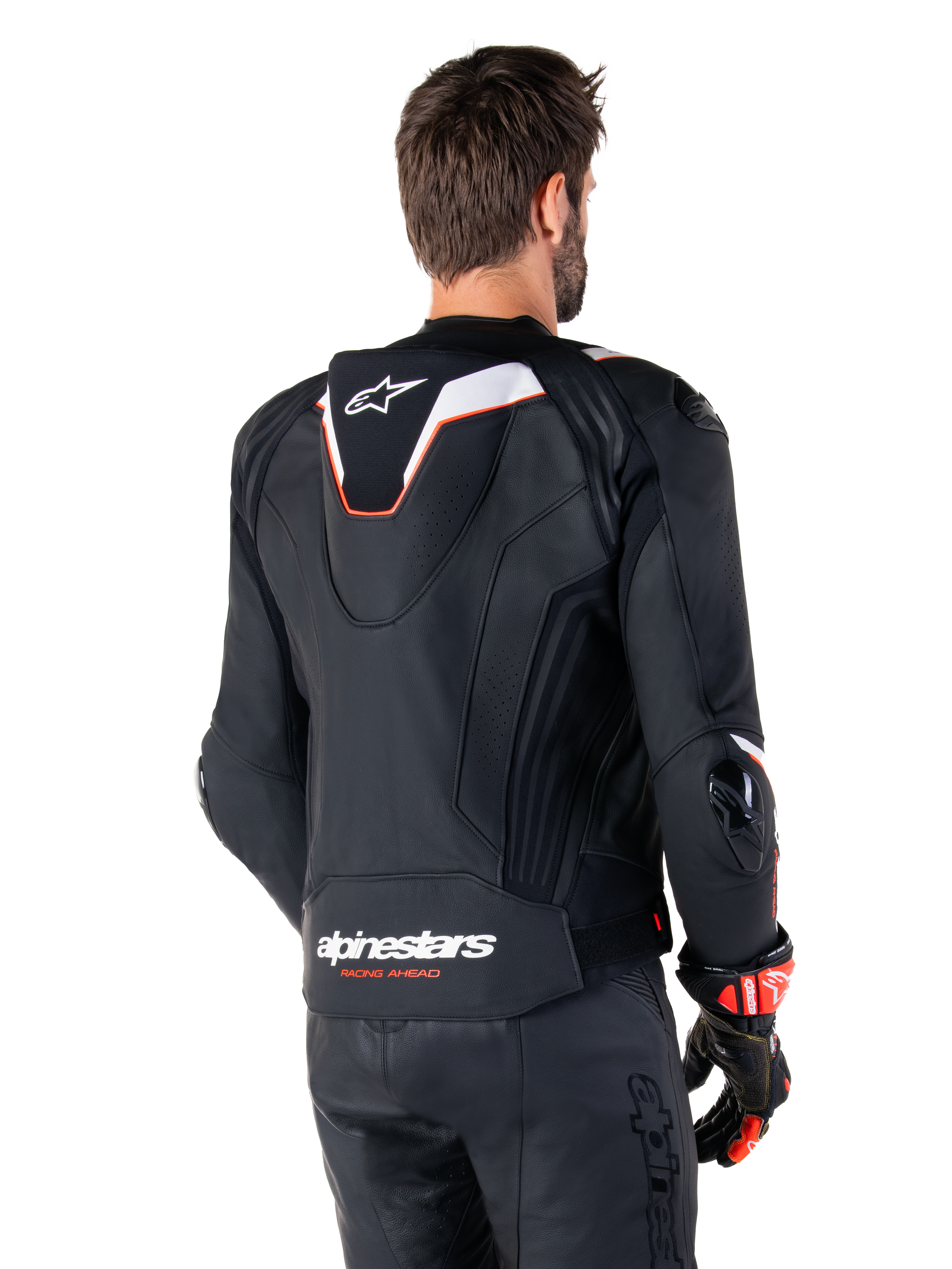 Chaqueta de cuero Alpinestars Missile V3 Ignition, vista trasera, negra con detalles en blanco y rojo, con joroba aerodinámica deportiva y logotipos de Alpinestars, usada con pantalones de cuero a juego y guantes de carreras