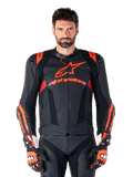 Chaqueta de cuero Alpinestars Missile V3 Ignition, chaqueta de carreras para moto, negra y roja fluo, usada con guantes de carreras y pantalones de cuero a juego, con ventilación perforada y marca Alpinestars destacada, equipamiento profesional para carreras