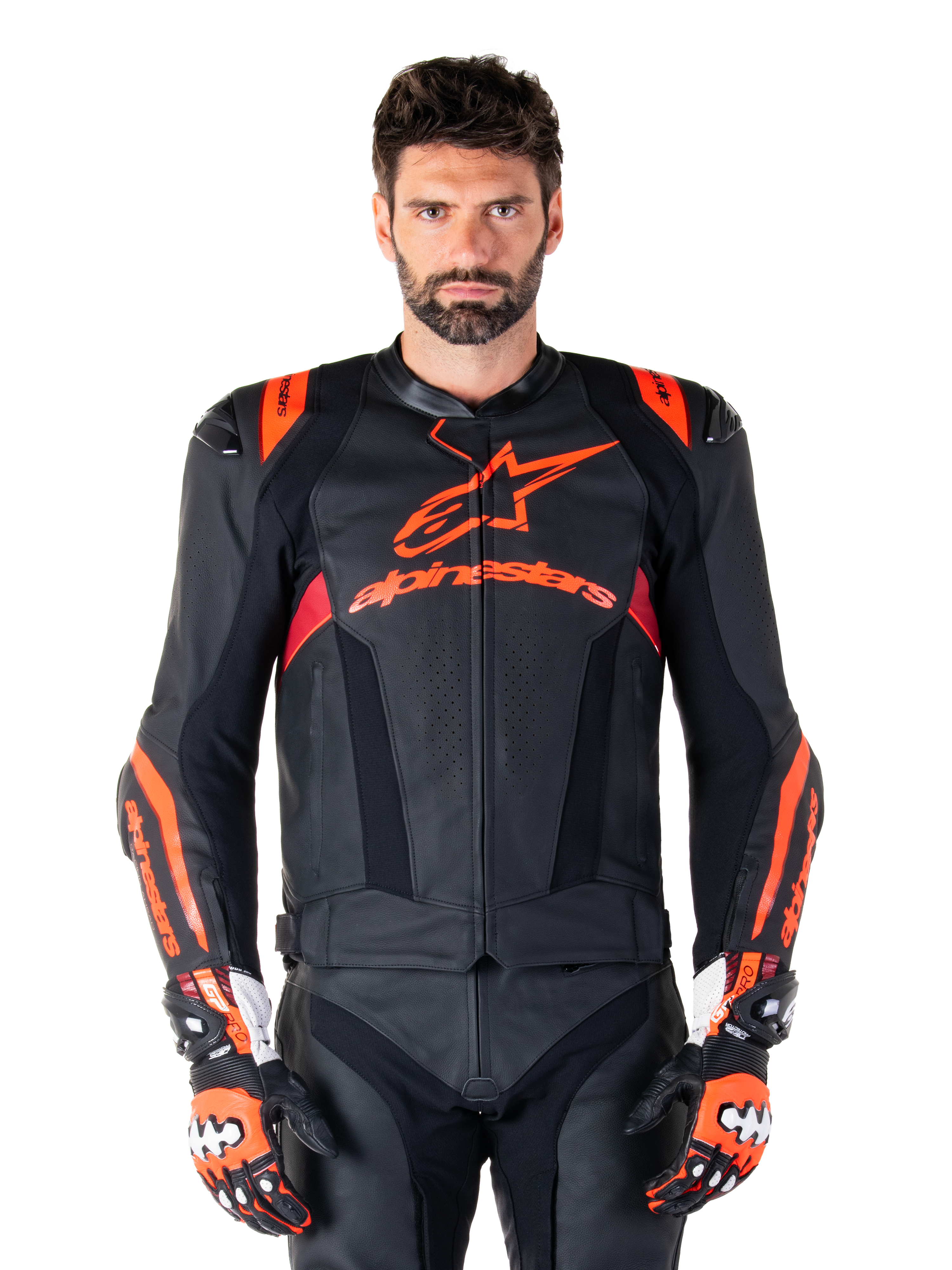 Chaqueta de cuero Alpinestars Missile V3 Ignition, chaqueta de carreras para moto, negra y roja fluo, usada con guantes de carreras y pantalones de cuero a juego, con ventilación perforada y marca Alpinestars destacada, equipamiento profesional para carreras