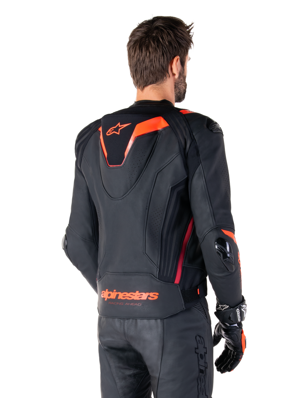 Alpinestars Missile V3 Ignition Leather Jacket, chaqueta deportiva de competición para hombre, negra con detalles en Rojo Fluo, vista trasera con la delgada joroba aerodinámica y el logotipo de Alpinestars en la parte inferior de la espalda, combinada con pantalones de cuero negros y guantes de carreras, diseño profesional de motociclismo deportivo