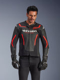 Alpinestars GP Force V2 Air Leather Jacket, Motorcycle Racing Jacket, Black and Red Fluo, premium leather construction with extensive perforations for airflow, worn by a model with black gloves and pants, featuring bold branding and 'Racing Ahead' text on the chest