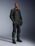 Modelo masculino con la chaqueta de cuero Alpinestars Dusk en Black Laser, combinada con pantalones de carreras de cuero negro a juego, guantes GP Pro y botas de pista de alto rendimiento. Equipamiento completo de carreras de motos con protección externa DFS en los hombros y un ajuste atlético y estilizado para conducción deportiva y en carretera.