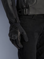 Alpinestars GP Plus V4 Leather Jacket, chaqueta de moto deportiva, negra, vista detallada del ajuste de cintura y cremallera de la manga, usada con guantes de moto negros, equipamiento de conducción profesional y elegante