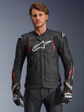 Alpinestars Dusk Airflow Leather Jacket, chaqueta de cuero para carreras de motos, negra con detalles en rojo flúor y blanco, con perforaciones extensas para ventilación, logotipo blanco en el pecho y deslizadores de hombros externos, vestida por un modelo con guantes de carreras a juego