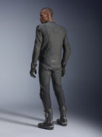Piloto masculino de espaldas vistiendo la chaqueta de cuero Alpinestars Dusk Airflow en color Black Black, combinada con pantalones de cuero, guantes y botas a juego, destacando las amplias perforaciones en la espalda y el ajuste deportivo de alto rendimiento.
