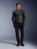 Chaqueta de cuero Alpinestars GP Plus R V4 Airflow, negra, lucida por un modelo masculino con guantes y pantalones negros a juego, con paneles de cuero perforado, gran logo de estrella tonal en el pecho y un ajuste deportivo estilizado para la conducción