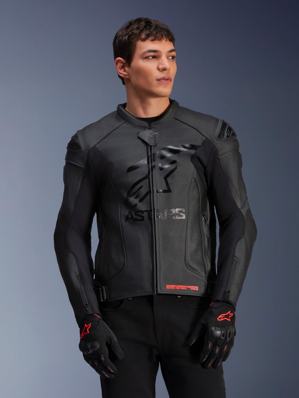 Alpinestars GP Plus R V4 Airflow, chaqueta de cuero para moto, negra, con construcción de cuero perforado, marca ASTARS destacada en el pecho y protección DFS en los hombros, usada con guantes negros y rojos