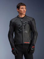 Alpinestars GP Plus R V4 Airflow, chaqueta de cuero para moto, negra, con construcción de cuero perforado, marca ASTARS destacada en el pecho y protección DFS en los hombros, usada con guantes negros y rojos