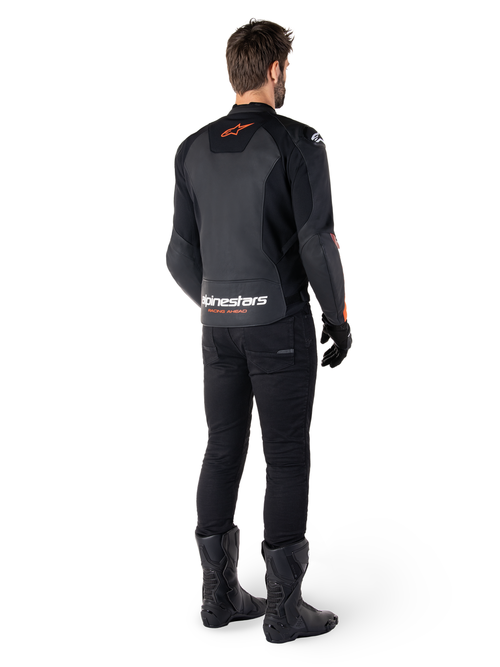 Alpinestars Faster V3 Leather Jacket, chaqueta de moto deportiva, negro y rojo flúor, vista trasera usada con pantalones negros y botas negras, con el texto 'alpinestars RACING AHEAD' en la parte baja de la espalda y un pequeño logotipo de estrella roja, confección de cuero con ajuste deportivo estilizado