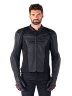 Hombre con la chaqueta de cuero Alpinestars Faster V3 Airflow, chaqueta negra de competición para motociclismo con paneles de cuero perforado, logo de Alpinestars en el pecho, guantes de conducción negros, foto de estudio frontal