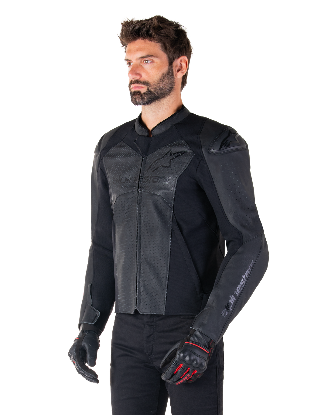 Modelo con la chaqueta de cuero Alpinestars Faster V3 Airflow en negro, chaqueta de moto deportiva con cuero perforado y paneles elásticos, combinada con pantalones negros y guantes negros con detalles rojos, estilo estilizado derivado de la competición.