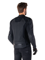 Chaqueta de cuero Alpinestars Faster V3 Airflow, negra, vista trasera de un hombre con una chaqueta deportiva de cuero para moto, con paneles traseros perforados, inserciones elásticas y el logotipo de Alpinestars en el dobladillo inferior, combinada con pantalones y guantes negros