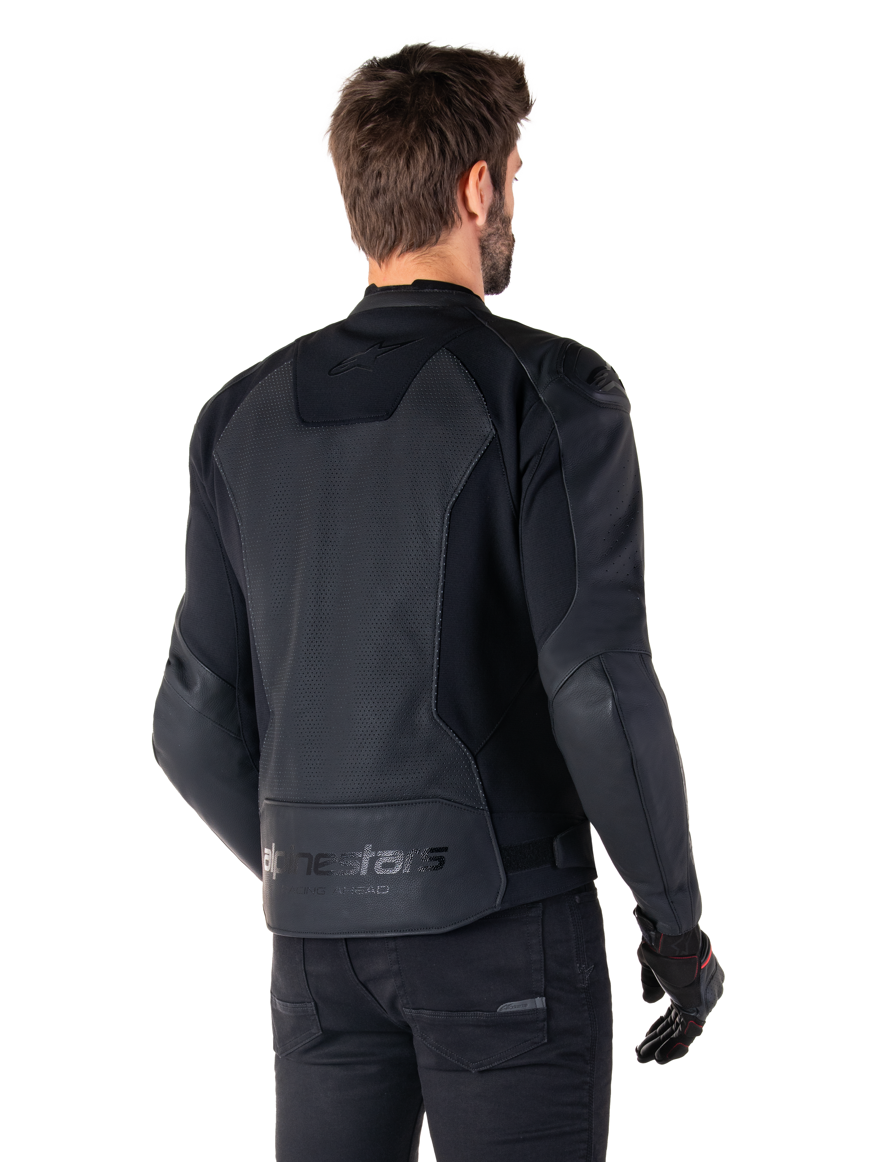 Chaqueta de cuero Alpinestars Faster V3 Airflow, negra, vista trasera de un hombre con una chaqueta deportiva de cuero para moto, con paneles traseros perforados, inserciones elásticas y el logotipo de Alpinestars en el dobladillo inferior, combinada con pantalones y guantes negros
