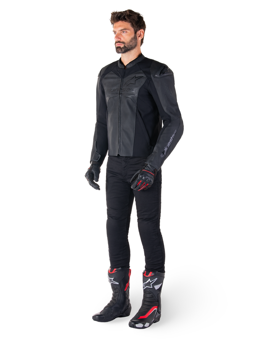 Hombre vistiendo la chaqueta de cuero Alpinestars Faster V3 Airflow en color negro, combinada con pantalones negros, guantes de moto negros y rojos, y botas de competición negras con detalles rojos y blancos, equipamiento de conducción deportiva de cuerpo completo