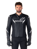 Alpinestars Faster V3 Airflow Leather Jacket, chaqueta de moto negra con detalles blancos, paneles de cuero perforados para ventilación, logotipo de Alpinestars en el pecho, usada con guantes negros, construcción de cuero de inspiración deportiva