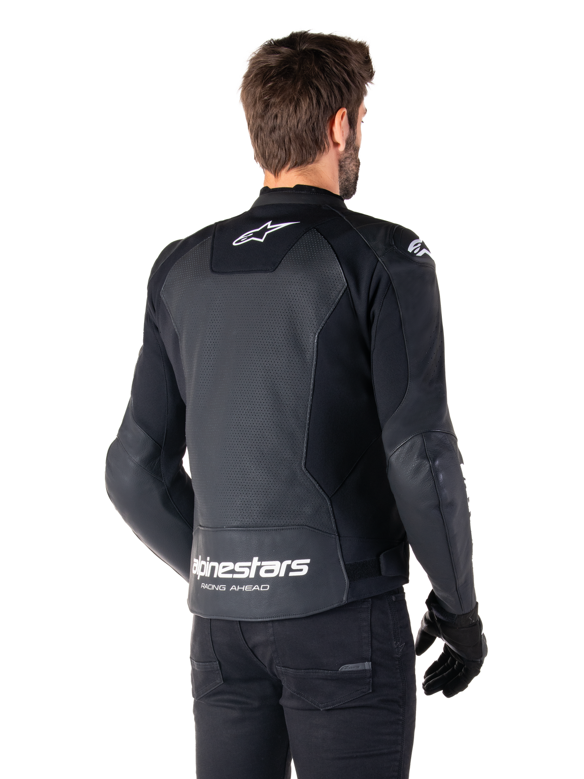 Chaqueta de cuero Alpinestars Faster V3 Airflow, negro y blanco, vista posterior en un modelo, con espalda de cuero perforado para ventilación, logos Astars blancos en la parte superior de la espalda y en la parte inferior de la cintura con el texto 'Racing Ahead', diseño deportivo con paneles elásticos para motociclismo.