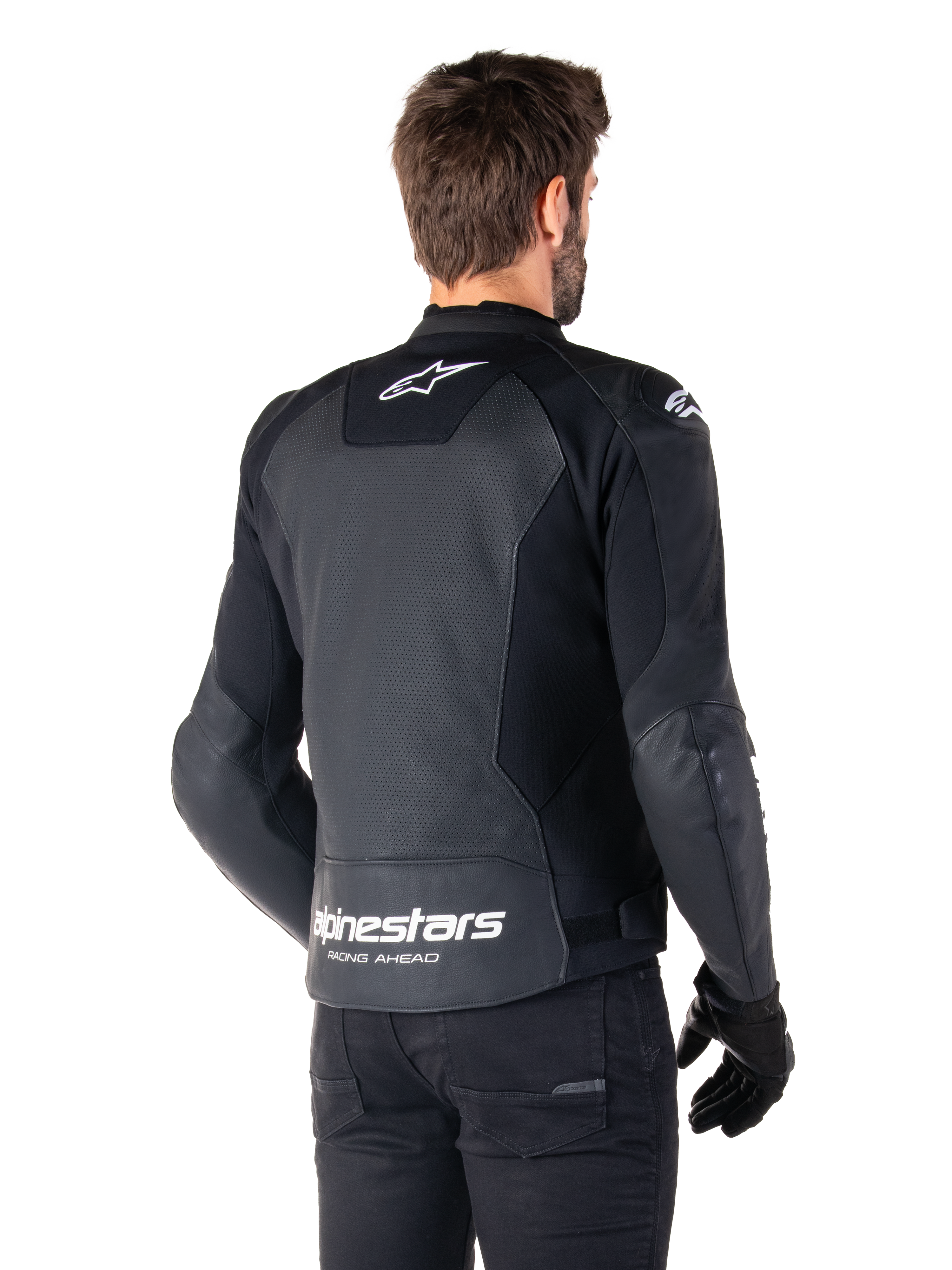 Chaqueta de cuero Alpinestars Faster V3 Airflow, negro y blanco, vista posterior en un modelo, con espalda de cuero perforado para ventilación, logos Astars blancos en la parte superior de la espalda y en la parte inferior de la cintura con el texto 'Racing Ahead', diseño deportivo con paneles elásticos para motociclismo.