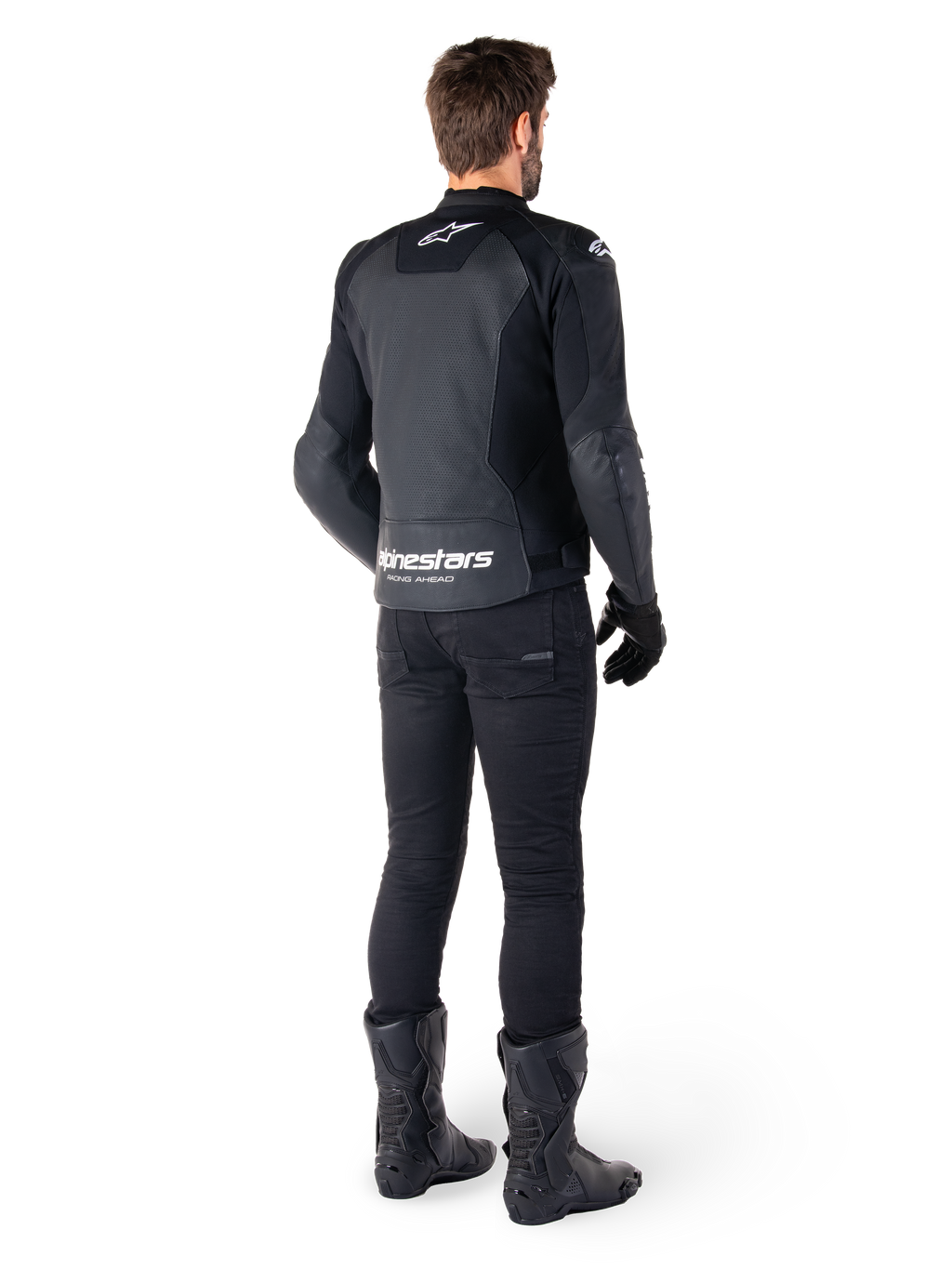 Chaqueta de cuero Alpinestars Faster V3 Airflow, negro y blanco, vista posterior que muestra los paneles de cuero perforados y el logotipo de Alpinestars en la parte baja de la espalda, vestida por un piloto con pantalones, guantes y botas de motorista negros.