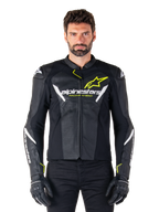 Chaqueta de cuero Alpinestars Faster V3 Airflow, negro, blanco y amarillo flúor, usada por un modelo masculino con guantes negros a juego, con paneles de cuero perforado para la ventilación y un llamativo logotipo de Alpinestars en el pecho, equipamiento deportivo para motociclismo