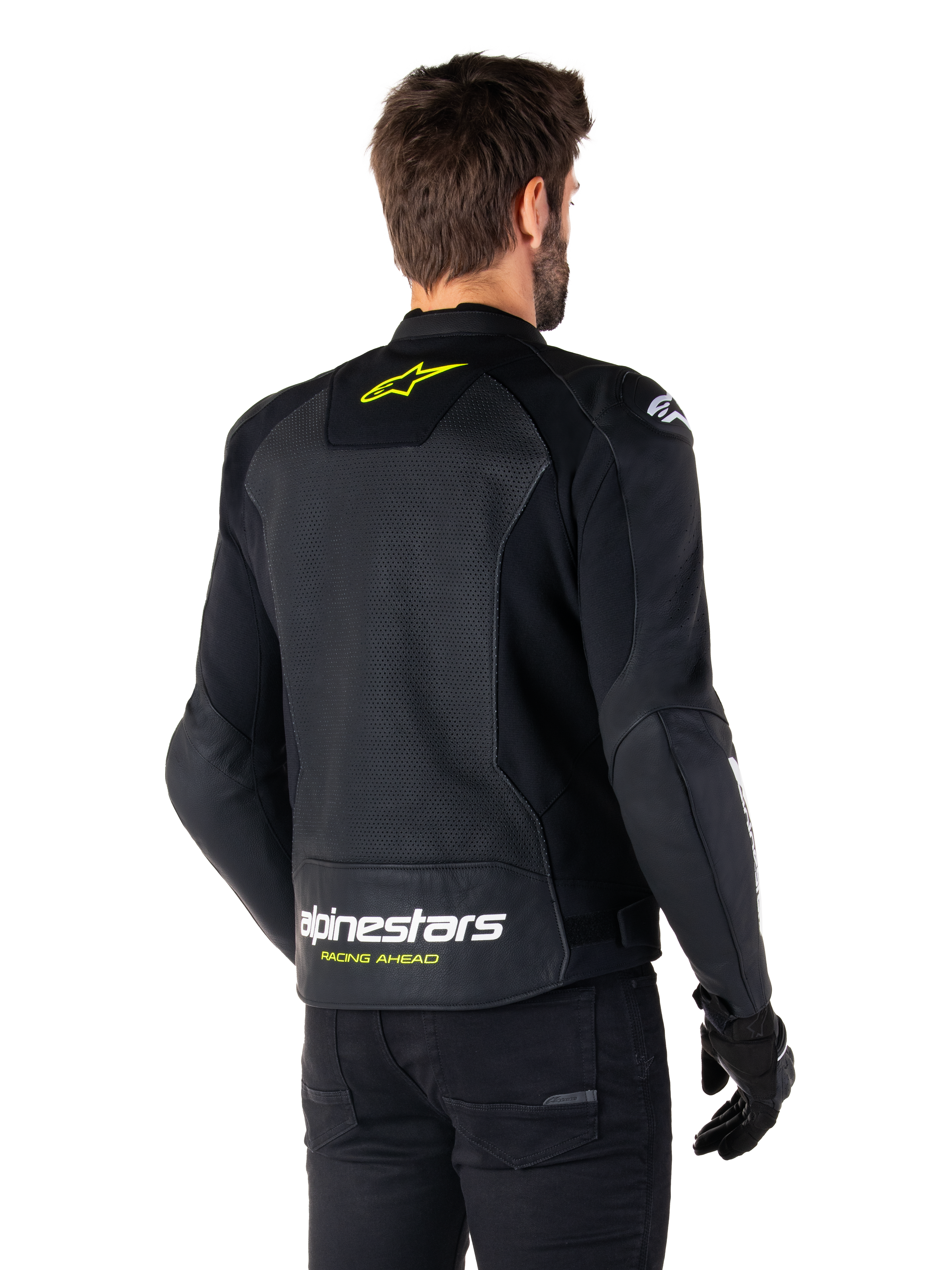 Chaqueta de cuero Alpinestars Faster V3 Airflow, negro, blanco y amarillo flúor, vista trasera, con un gran panel trasero de cuero perforado para ventilación, logo de estrella amarilla en el cuello y marca Alpinestars en blanco con el texto 'Racing Ahead' en amarillo en el dobladillo inferior, equipamiento deportivo para conducción de motocicleta
