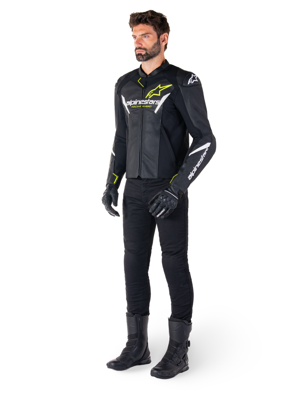 Piloto masculino con la chaqueta de cuero Alpinestars Faster V3 Airflow en negro, blanco y amarillo flúor, combinada con pantalones y botas de moto negros, con paneles de cuero perforado, detalles de logotipos en blanco y acentos en amarillo neón, equipamiento profesional de conducción deportiva