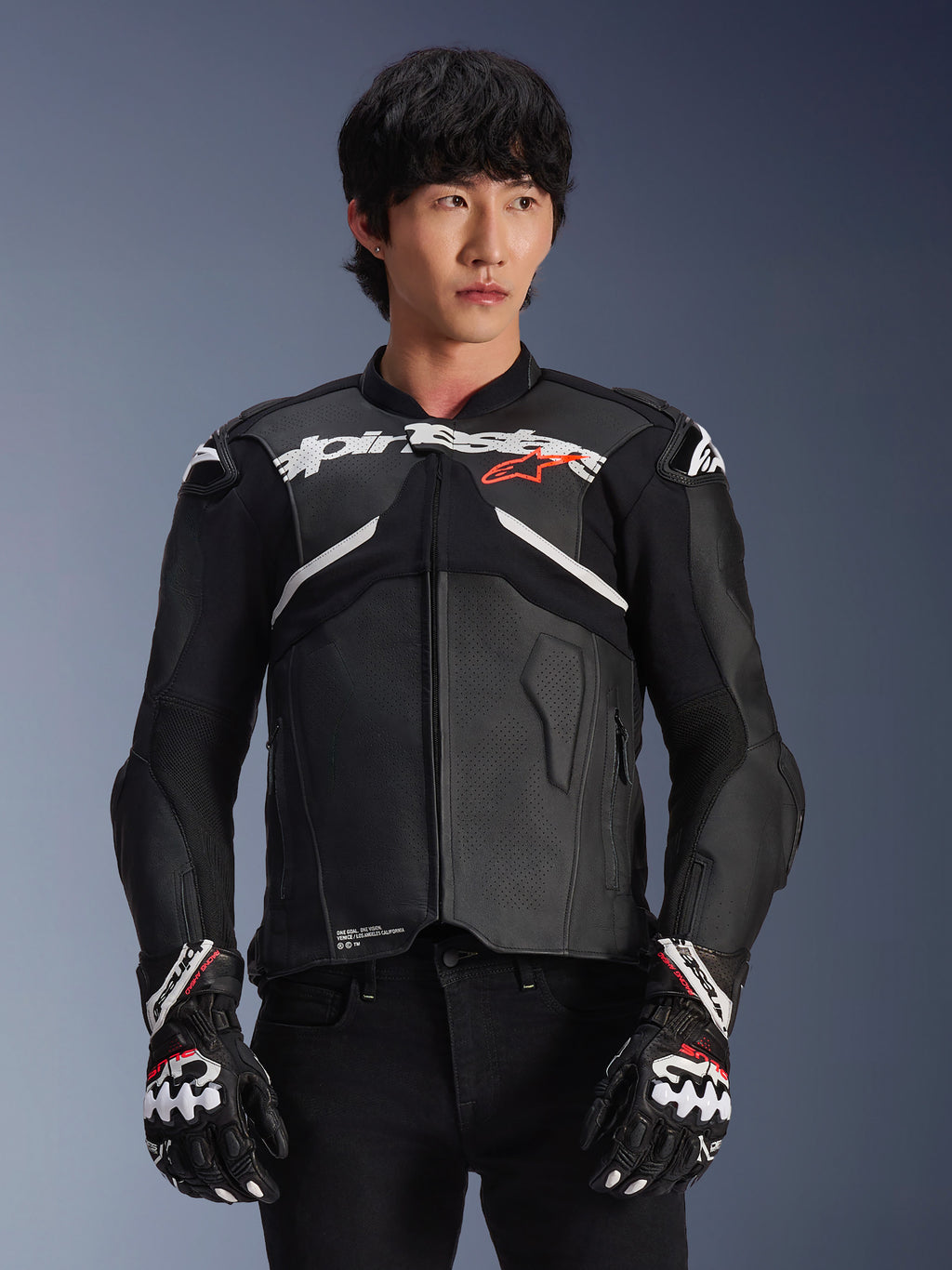 Chaqueta de cuero Alpinestars Atem V5, chaqueta de carreras para moto, negra con detalles en blanco y rojo, construcción de cuero premium con protecciones, usada con guantes de carreras a juego