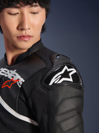 Primer plano de la chaqueta de cuero Alpinestars Atem V5 en negro y blanco, con el protector de hombro DFS RR con el logotipo de la estrella blanca, construcción de cuero perforado y gráficos en el pecho inspirados en la competición.
