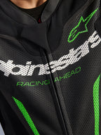 Traje de cuero Alpinestars GP Force V2 - 1 pieza, primer plano de la zona del pecho, cuero perforado negro con el logotipo de Alpinestars en blanco, texto 'RACING AHEAD' en verde y detalles en verde