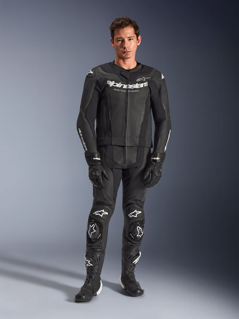 Alpinestars GP Force V2, mono de cuero de dos piezas para moto, negro con logos blancos, protección reforzada en rodillas y pecho, diseño completo con guantes y botas