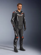 Alpinestars GP Force V2 2-Piece Leather Suit, negro, blanco y rojo flúor, usado por un modelo con botas y guantes de carreras negros, con paneles de cuero perforado, acentos aerodinámicos blancos y logotipos en rojo flúor en hombros y rodillas, equipo profesional de carreras de motociclismo