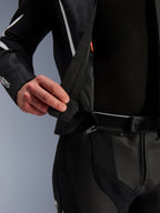 Alpinestars GP Force V2 Leather Suit - 2 Piece, detalle en primer plano de la cremallera de conexión de 360 grados en la cintura, cuero perforado negro con detalles blancos, mostrando el sistema de unión segura entre la chaqueta y el pantalón.