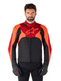 Alpinestars T-Jaws V4 Waterproof Jacket, chaqueta textil de moto deportiva, negra con detalles en rojo flúor y rojo oscuro, lucida por un modelo masculino con guantes a juego, equipamiento técnico con un destacado logotipo de estrella en el pecho.