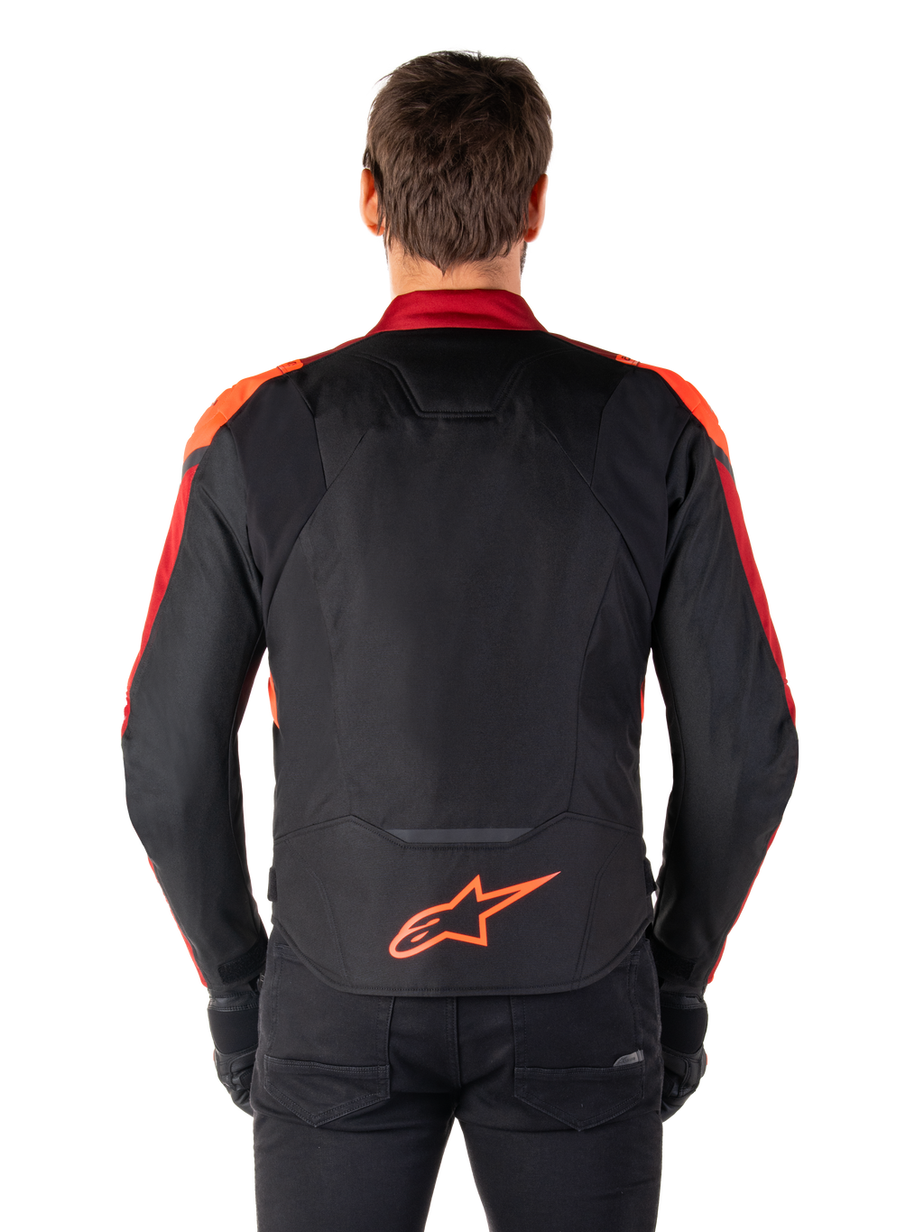 Chaqueta Alpinestars T-Jaws V4 Waterproof, vista trasera, color negro con detalles en rojo flúor y rojo oscuro, logotipo naranja en la parte inferior de la espalda, panel trasero extendido para mayor cobertura al conducir, chaqueta de moto textil deportiva