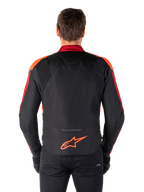 Chaqueta Alpinestars T-Jaws V4 Waterproof, vista trasera, color negro con detalles en rojo flúor y rojo oscuro, logotipo naranja en la parte inferior de la espalda, panel trasero extendido para mayor cobertura al conducir, chaqueta de moto textil deportiva