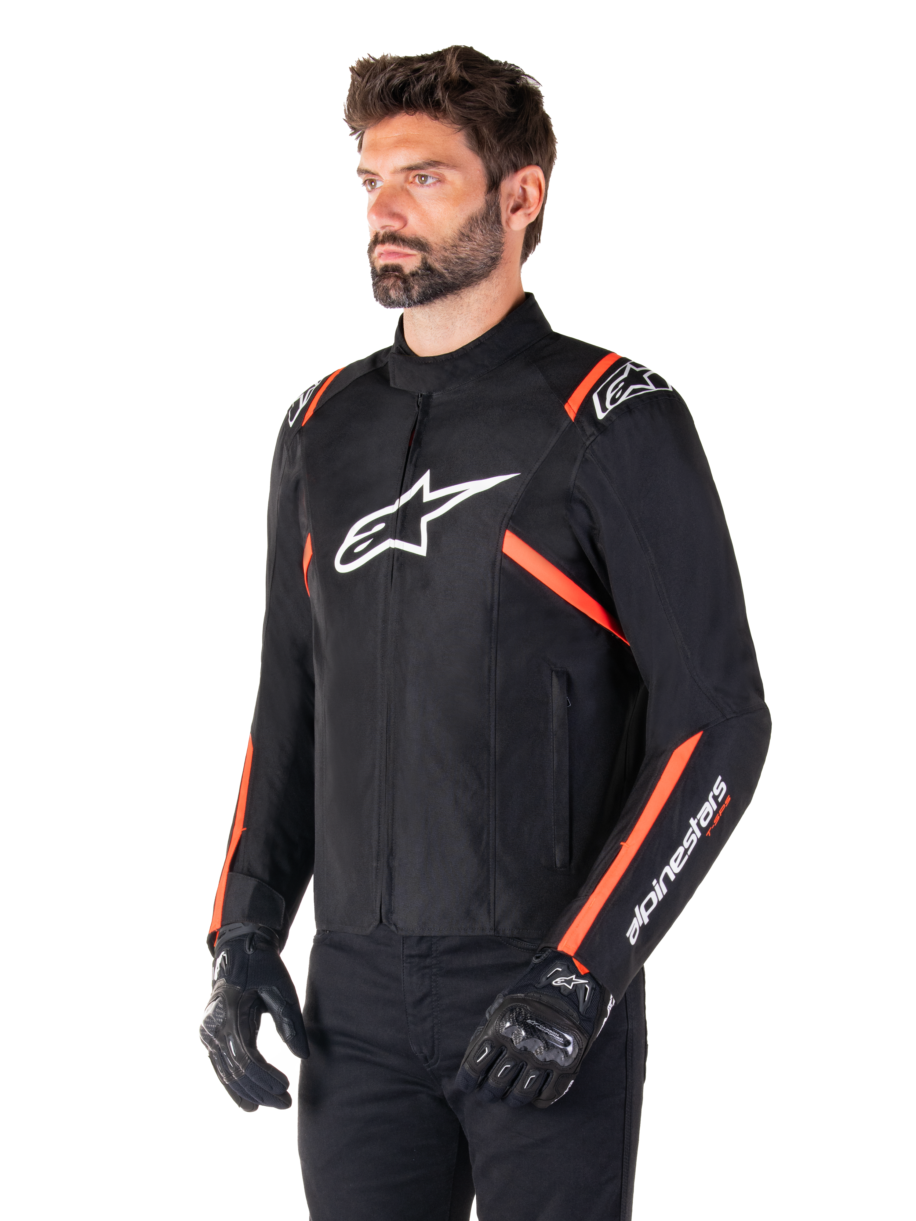 Chaqueta impermeable Alpinestars T-SPS V2, negro, blanco y rojo fluorescente, usada por un modelo masculino con guantes y pantalones negros, con logo blanco de Alpinestars en el pecho y detalles en rojo fluorescente en hombros y mangas, diseño textil deportivo