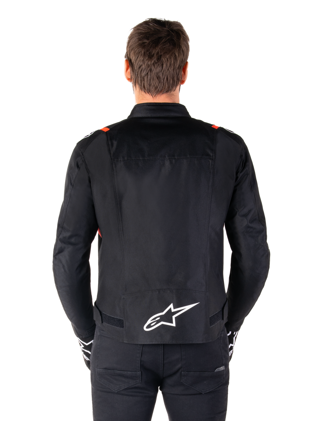 Chaqueta impermeable Alpinestars T-SPS V2, negro con detalles en blanco y rojo flúor, vista trasera con un gran logotipo blanco de Alpinestars en la parte inferior de la espalda, chaqueta de moto textil de corte deportivo, combinada con pantalones y guantes negros