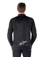 Chaqueta impermeable Alpinestars T-SPS V2, negro con detalles en blanco y rojo flúor, vista trasera con un gran logotipo blanco de Alpinestars en la parte inferior de la espalda, chaqueta de moto textil de corte deportivo, combinada con pantalones y guantes negros