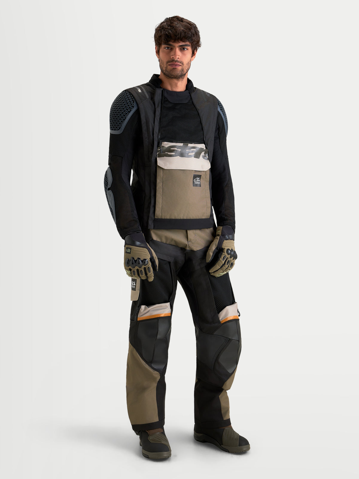 Alpinestars Harok V2 Drystar, chaqueta de aventura para moto de hombre en aluminio, marrón y negro, con diseño ventilado y construcción impermeable, vestida por un modelo masculino.